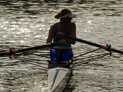运动型年轻女士在水上划船图片