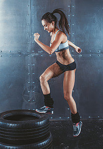 女运动员正在从事轮胎跳跃健身体育培训和生活方式概念的演练工作图片