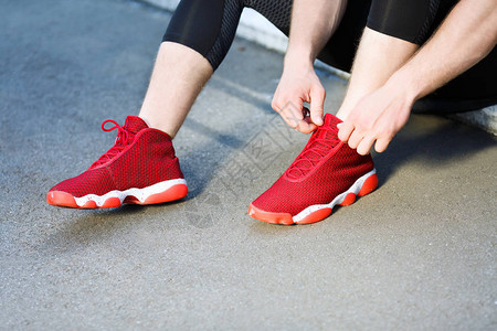体育概念运动员坐在红色运动鞋上并加图片