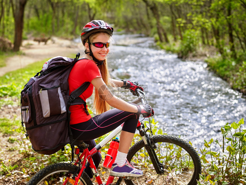 骑自行车的女孩背着大背包的快乐女孩骑自行车女孩骑自行车涉水骑自行车旅行有益于健康骑自行车的图片
