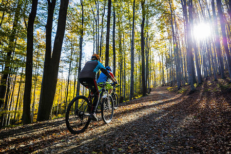 贝斯基迪山森林景观秋天的男女赛车手夫妇骑着MTB内特罗轨道图片