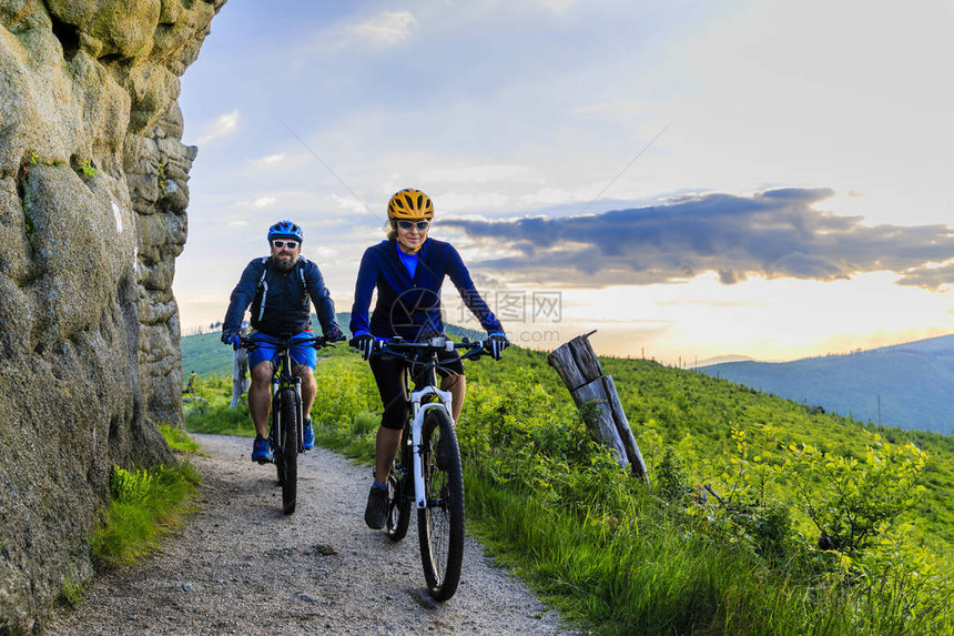 山地自行车妇女和男子骑自行车在日落山林景观情侣骑自行车MTBenduro流径赛道图片