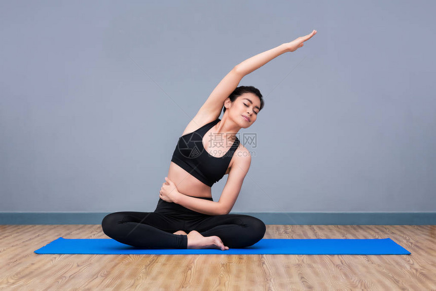 年轻的亚洲女在瑜伽健康运动馆练习瑜伽姿势图片