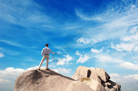 年轻人站在悬崖的边缘看着一图片