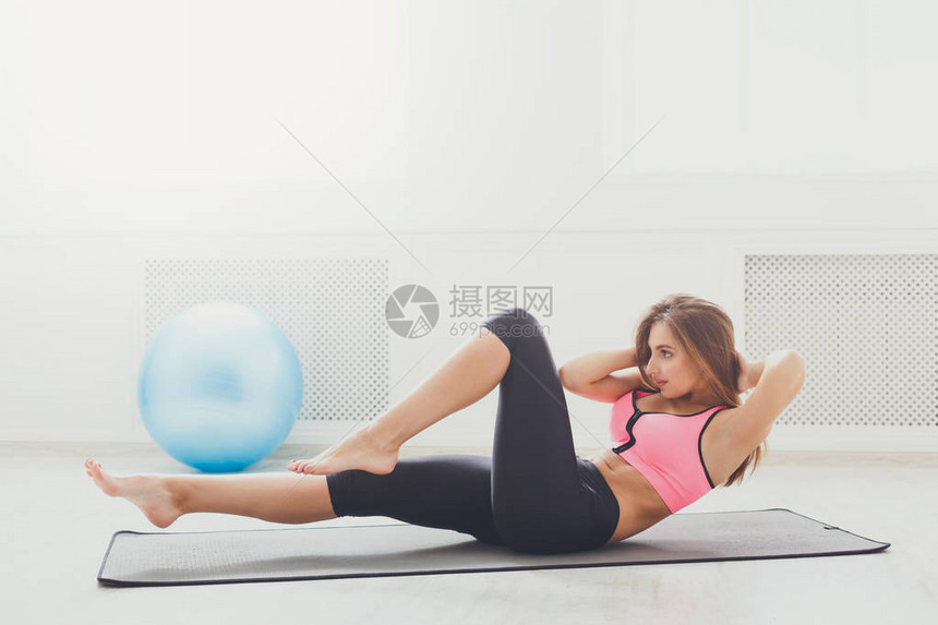 躺在健身房赤脚做仰卧起坐的健身女人年轻的型女孩在垫子上做仰卧起坐健康生活方式体图片