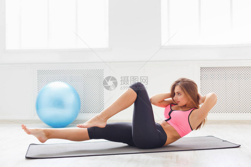 躺在健身房赤脚做仰卧起坐的健身女人年轻的运动型女孩在垫子上做仰卧起坐健康生活方式体图片