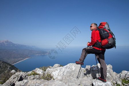 旅人站在山顶眺望大海背景图片