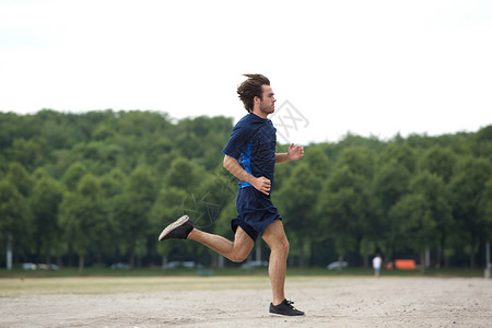 一个运动青年男子在户外跑动的图片