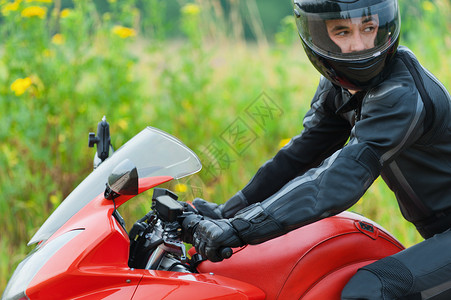 肖像帅哥皮盔制服坐着摩托车转身田野花图片