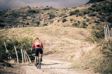 山地车手骑在秋季山区的自行车单轨小道上在乡村公路或单轨上骑山地车的男子骑手美丽的励志景观中的健背景图片