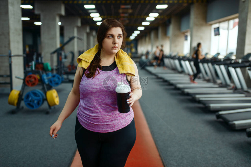 超重的女人在健身房喝减肥鸡尾酒图片