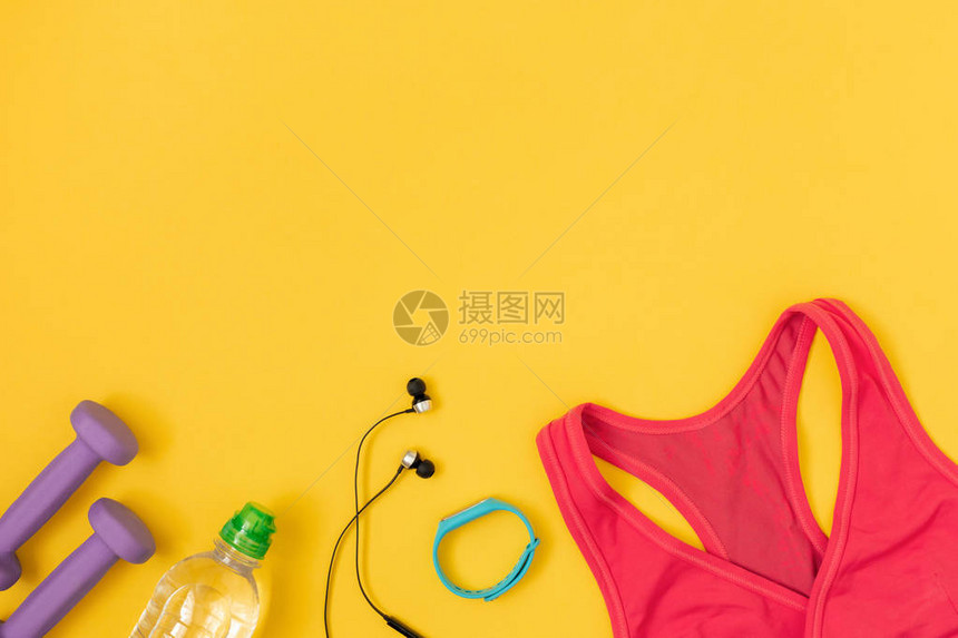 黄色背景的女子运动用品和瓶装水平底露图片