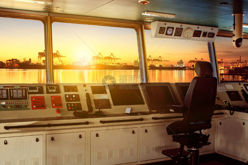 现代工业船只轮式控制委员会夜间接近港湾图片