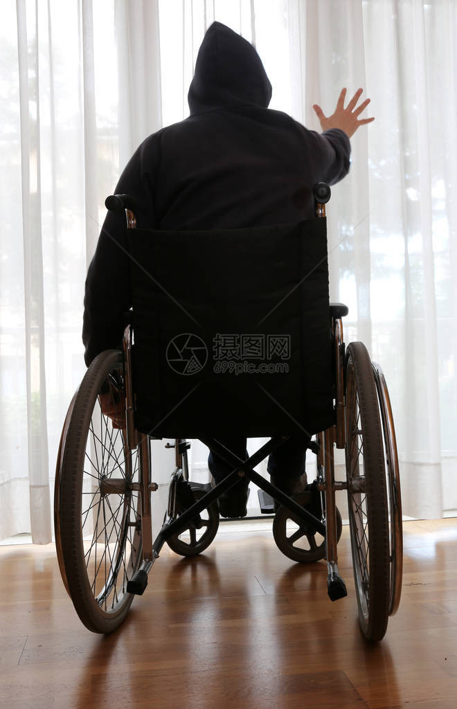 坐在轮椅上的残疾人在他的卧室里图片
