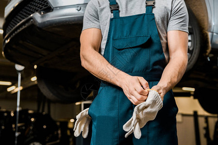 汽车修理车间穿着防护手套的身着制服的汽车机图片