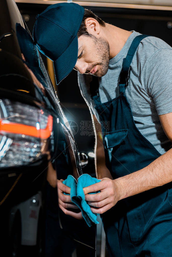 汽车修理店用抹布洗车的青年汽车图片