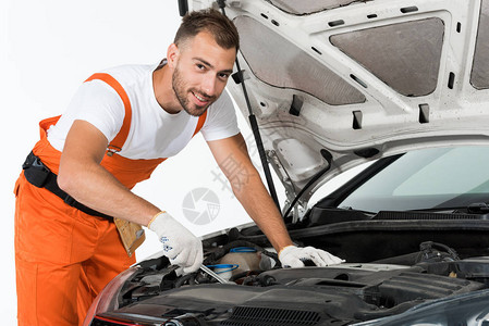 英俊的汽车修理工汽车修理工用白色扳手修理汽车图片