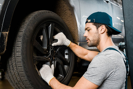 在汽车修理车间对汽车轮进行防护手套检查时看到汽车图片
