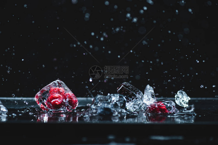 冰晶中熟的冻浆果的近视画面在黑图片