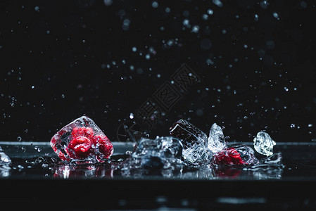 冰晶中熟的冻浆果的近视画面在黑背景图片