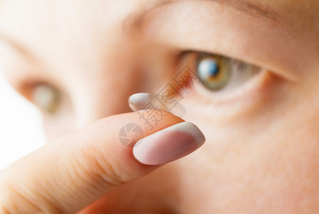 女眼睛和隐形眼镜专注于手指图片