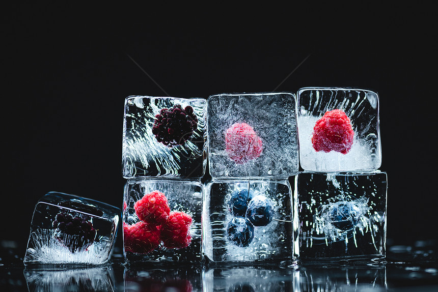 黑色冰晶中成熟美味冷冻浆果的特写视图图片