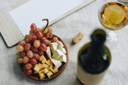 玻璃杯配白葡萄酒葡萄奶酪和剪贴板图片