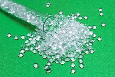 绿色背景上的透明聚乙烯颗粒游离双酚A的概念HDPE塑料颗粒塑料原图片