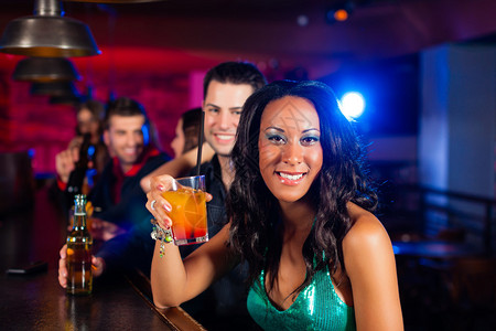 一群在酒吧或俱乐部里喝鸡尾酒的派对人士图片