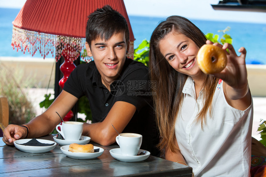 年轻夫妇在海边吃早餐的特写镜头图片