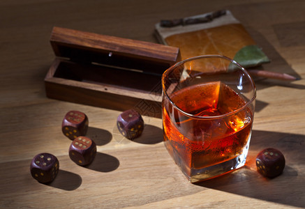 木桌上的威士忌和骰子图片