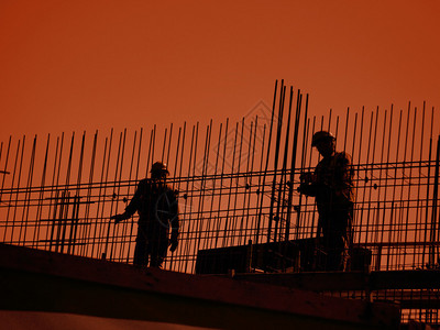 从事钢加固工作的建筑工人的轮椅再次呈背景图片