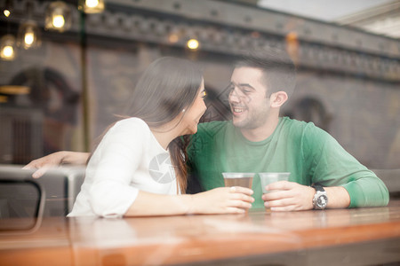 英俊的年轻人在酒吧里喝酒啤酒和调情图片