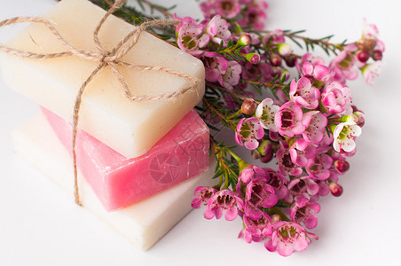白色和粉红色的手工肥皂和白色背景上的粉红色樱花图片