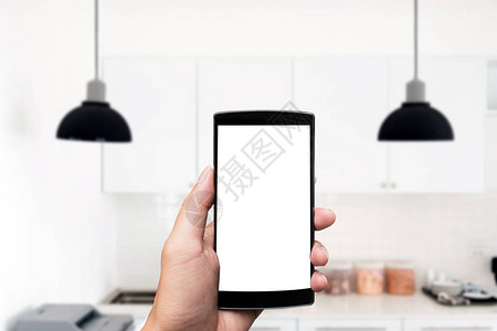 手持智能手机在厨房空白屏图片
