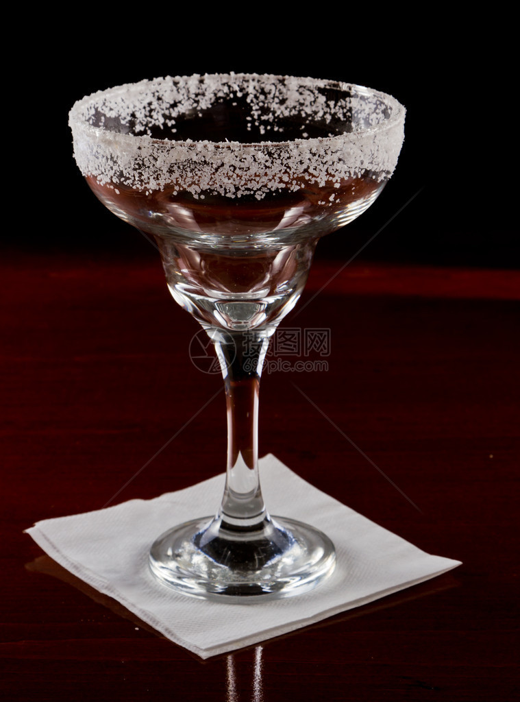玛格丽塔酒杯装饰着盐边服在黑暗的棒子上图片