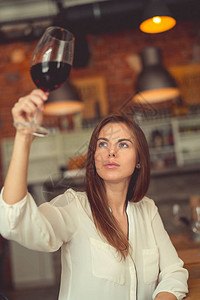 在餐厅里端着一杯红酒的年轻侍酒师图片