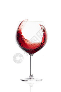 红酒在一个气球玻璃杯中喷雾白底孤图片