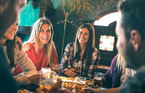 一群快乐的朋友在啤酒吧餐厅喝啤酒与千禧一代年轻人一起享受时图片