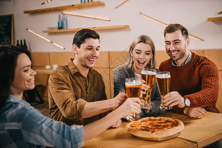 一群快乐的朋友在酒吧的比萨图片