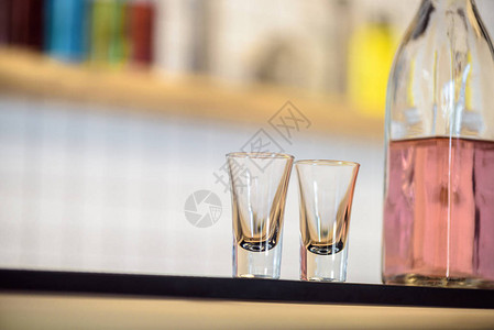 酒吧柜台上空玻璃杯和装有酒精饮料图片