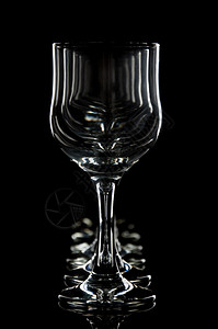 黑色背景上的酒杯和水反映背景图片