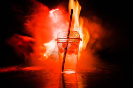 俱乐部饮料的杯子在深尖雾背景下燃烧图片