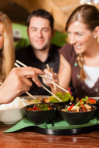 年轻人在泰国餐馆吃饭他们用筷图片