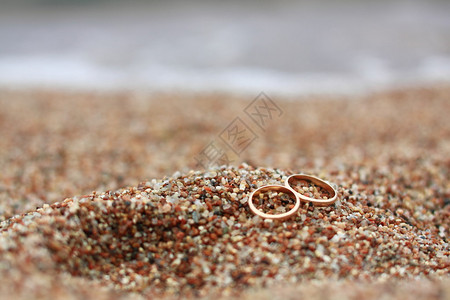 沙滩上的结婚戒指背景图片