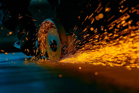 工人用研磨机切割金属研磨铁时亮的火花背景图片