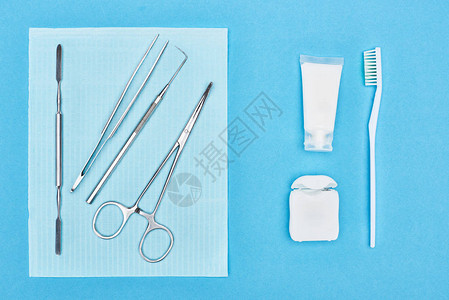 在牙膏和牙刷附近用牙科工具设置的顶部视图图片