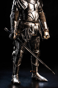 穿着盔甲的骑士在黑色背景上手持的剪影图片