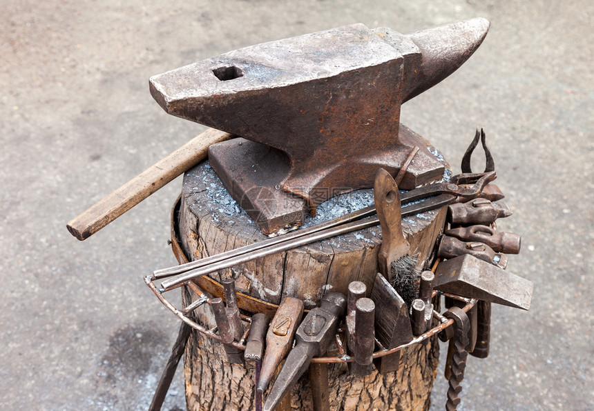户外有铁匠工具的旧铁砧图片