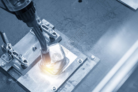 用于在浅蓝色场景中焊接汽车零件的焊接机器人现代制造工艺的工业图片